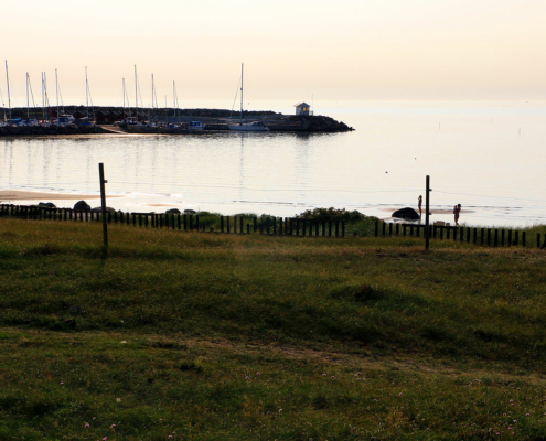 Vy över spegelblankt hav och hamn Haverdal