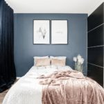 Blått sovrum med svarta skjutdörrar i garderob, aprikos filt