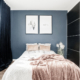 Blått sovrum med svarta skjutdörrar i garderob, aprikos filt