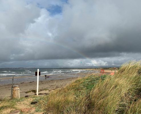 Vilshärad strand med regnbåge