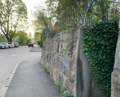 Mur med murgröna vid sluttande trottoar